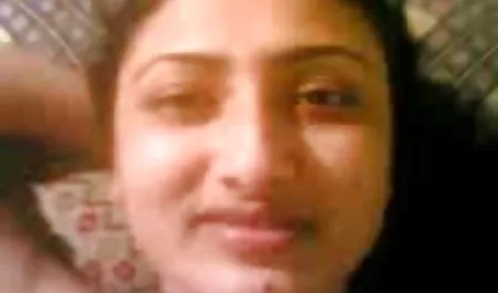 Hermosa morena con lápiz labial rojo en los linda tetona labios chupando un hombre tendido en la cama.
